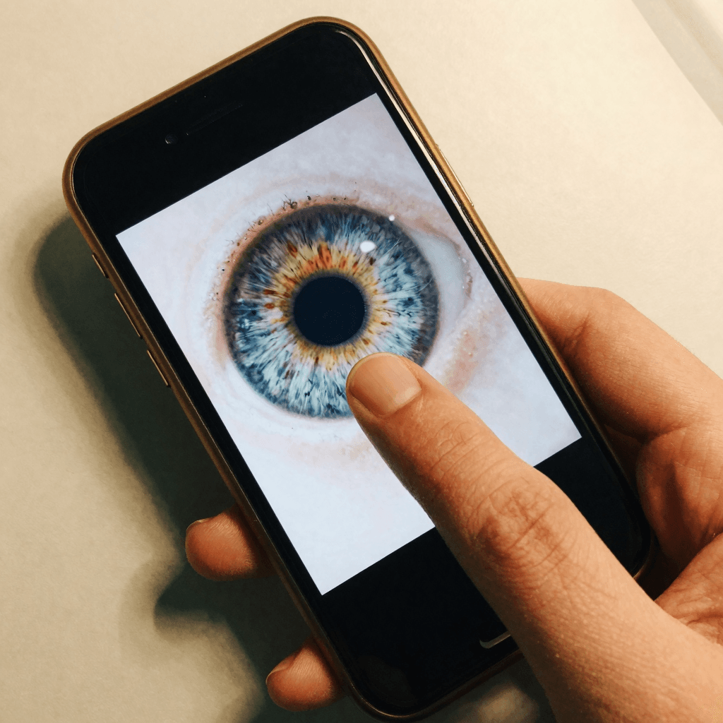 Photo of a finger held on the iris on a phone screen to lock focus